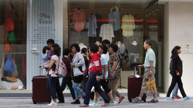 <p>
	Туристи на улица Гинза в Токио. <em>Снимка: Архив Ройтерс</em></p>
