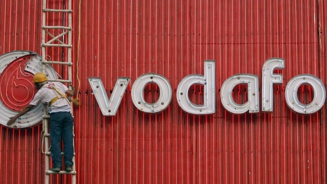 <p>
	Служител на Vodafone в Индия ремонтира светеща реклама край Делхи. <em>Снимка: Ройтерс</em></p>
