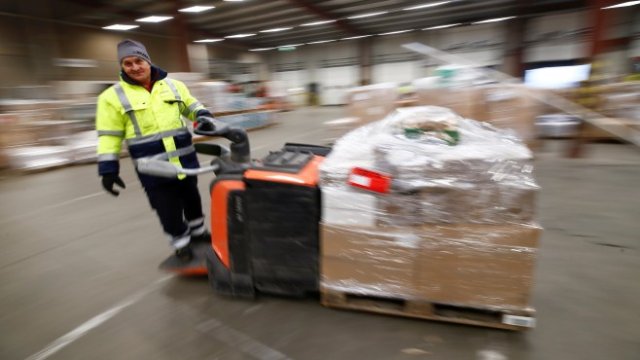 <p>
	Служител на германската пощенска и логистична група Deutsche Post DHL премества палети в логистичен център за товари на DHL, разположен близо до границата на Германия са Франция и Люксембург в Шелем, Германия, 12 декември 2018 г<em>. Снимка: Ройтерс.</em></p>
