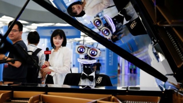 <p>
	Роботът Тео Тронико, проектиран от Матео Сузи, свири на пиано и пее популярни песни по време на конференция за роботиката в Пекин. 22 август 2017 г. <em>Снимка: Ройтерс</em></p>
