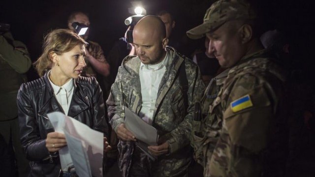 <p>
	Представителите на украинските правителствени сили (в центъра и вдясно) и на проруските бунтовници от Източна Украйна (вляво) разговарят преди да започне размяната на задържаните.<em> Снимка: Ройтерс</em></p>
