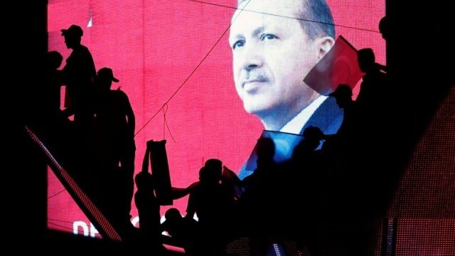 <p>
	Силуетите на поддръжници на турския президент Реджеп Тайип Ердоган се виждат на фона на екран с образа му, който стоеше в центъра на проправителствената демонстрация в Истанбул снощи. <em>Снимка: Ройтерс</em></p>
