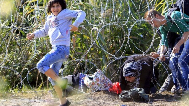 <p>
	Сирийско семейство преминава границата на Унгария и Сърбия.<em>&nbsp;</em><em>Снимка: Ройтерс</em></p>
