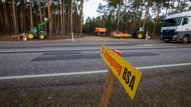 <div class="text-wrap tlid-copy-target">
	<div class="result-shield-container tlid-copy-target" tabindex="0">
		<span class="tlid-translation translation" lang="bg"><span title="">Превозни средства на пътя за достъп до гората по време на полагането на основите на гигафабриката на Tesla Inc. в Груенхайде, Германия, в понеделник, 13 януари 2020 г. 