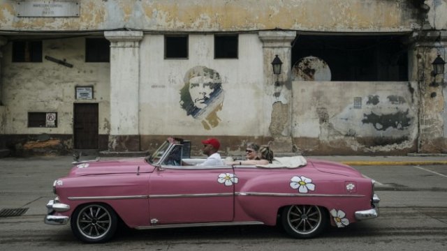 <p>
	Туристи се наслаждават на разходка в столицата Хавана. <em>Снимка: Francesco Pistilli/Bloomberg</em></p>
