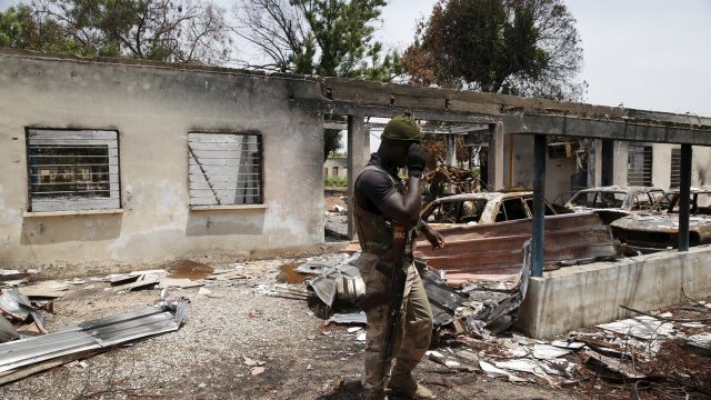 <p>
	Нигерийски войник върви през останките на един от унищожените градове.&nbsp;<em>Снимка: Ройтерс</em></p>
