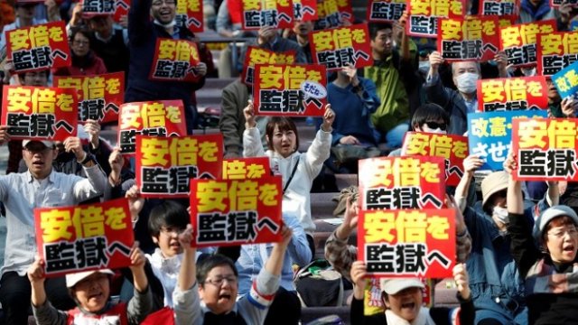 <p>
	Протестиращи с плакати &bdquo;Абе трябва да отиде в затвора&ldquo; в Токио, 25 март 2018 г. <em>Снимка: Ройтерс</em></p>
