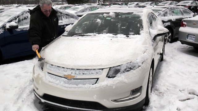 <p>
	Дилър на автомобили чисти Chevrolet Volt от снега. <em>Снимка: Ройтерс</em></p>
