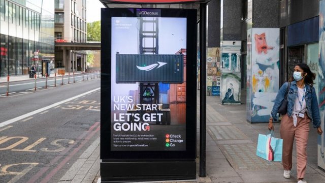 <p>
	Пешеходец минава покрай реклама от кампанията на правителството на Обединеното кралство &bdquo;Да тръгваме&ldquo; на автобусна спирка в Лондон, Великобритания, в сряда, 15 юли 2020 г. &nbsp;<em>&nbsp; Снимка: Simon Dawson/Bloomberg </em></p>

