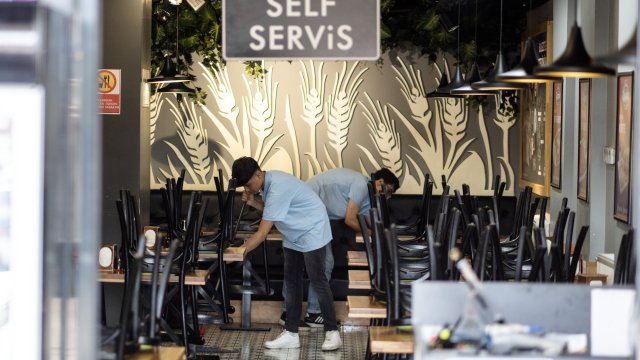 Работник чисти под в кафе за самообслужване в Анкара. Снимка: Moe Zoyari/Bloomberg