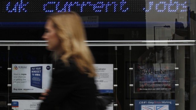 <p style="text-align: center;">
	Жена минава край център за наемане на работа в центъра на Лондон. <em>Снимка: Ройтерс</em></p>
