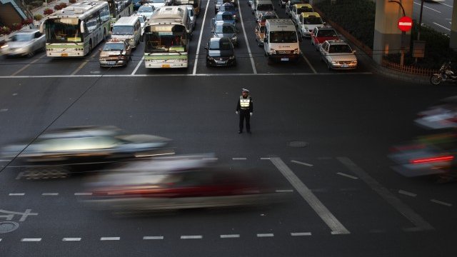 <p>
	Пътен полицай регулира трафика в Шанхай, Снимка: <em>Ройтерс</em></p>
