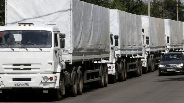 <p>
	Камионите с руската хуманитарна помощ преминават проверка на граничния пункт на Луганска област. <em>Снимка: Ройтерс</em></p>
