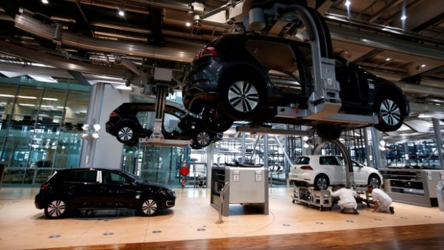 <p>
	Служители сглобяват e-Golf на нова производствена линия в завода на германския концерн Volkswagen в Дрезден. <em>Снимка: Архив Ройтерс</em></p>
