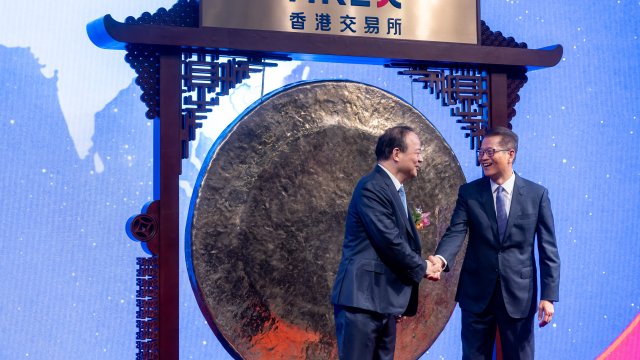 Робин Дзен, основател и председател на CATL  се здрависва с Пол Чан, финансов секретар на Хонконг, по време на церемонията по листването на компанията в Хонконг. Снимка: Paul Yeung/Bloomberg