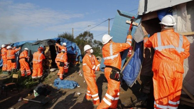<p>
	Санитарни работници разрушават временни постройки и премахват палатки от мястото. <em>Снимка: Ройтерс</em></p>
