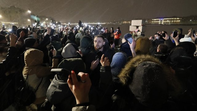 Хора полагат цветя и палят свещи до снимката на Алексей Навални по време на бдение близо до мемориала на политическите затворници в Санкт Петербург. Снимка: БГНЕС/EPA/Анатолий Малцев