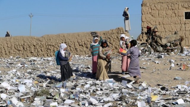 <p>
	Ученици събират книги от земята след поредните разрушения. <em>Снимка: Архив Ройтерс</em></p>
