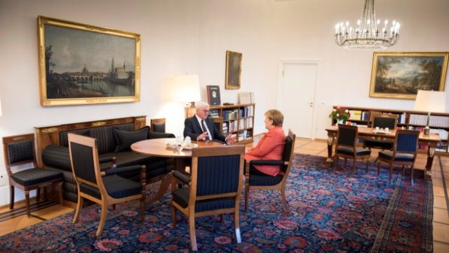 <p>
	Щайнмайер разговаря с канцлера Меркел. <em>Снимка: Ройтерс</em></p>
