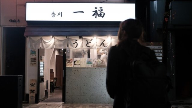 <p>
	<em>Човек върви към удон ресторант в Шибуя, Токио. Снимка:&nbsp;Soichiro Koriyama/Bloomberg</em></p>
