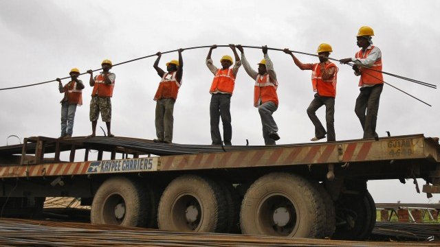 <p>
	Работници разтоварват железни пръти от камион при строителна площадка на образователен институт в покрайнините на западния индийски град Ахмедабад. <em>Снимка: архив Ройтерс</em></p>
