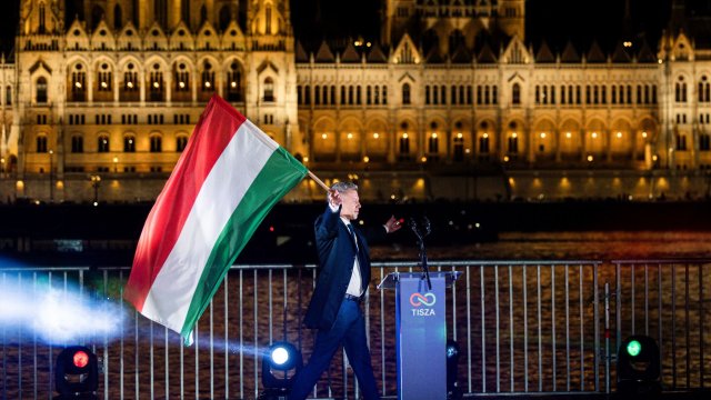 Победителят във вота Петер Мадяр, лидер на опозиционната партия Тиса, с унгарския флаг на фона на гледката към парламента от брега на Дунав в Будапеща. Снимка: Bloomberg LP