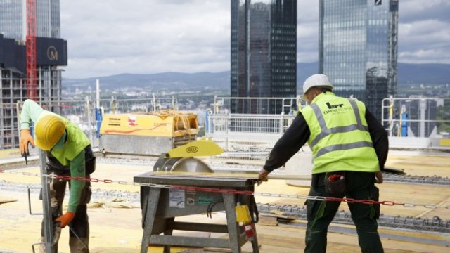 <p>
	<em>Строителни работници подготвят дървени плоскости на 24-ия етаж на 45-етажния жилищен и офис блок Omiturm във Франкфурт. Снимка: Alex Kraus/Bloomberg</em></p>
