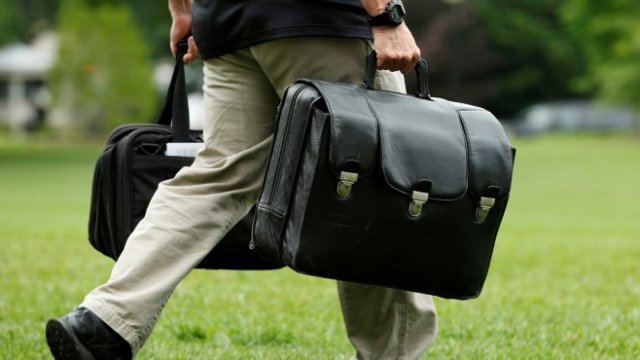 <p>
	<em>Служител на Белия дом носи чанта с кодовете за ядрени оръжия. Снимка: Архив Ройтерс</em></p>
