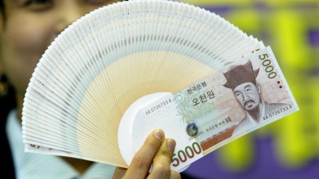 <p>
	Служител на южнокорейската централна банка с банкноти от 5 хил. вона. <em>Снимка: Архив Ройтерс</em></p>
