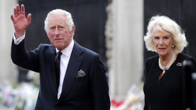 Крал Чарлз Трети и съпругата му Камила поздравяват събралото се множество при пристигането си в Бъкингамския дворец в Лондон. Снимка: EPA/БГНЕС