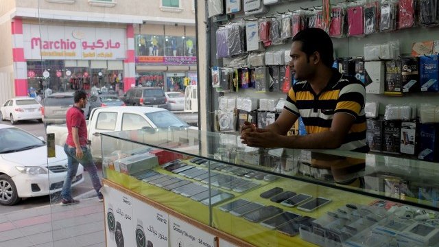 <p>
	Индийски търговец на мобилни телефона в Рияд. <em>Снимка: Архив Ройтерс</em></p>
