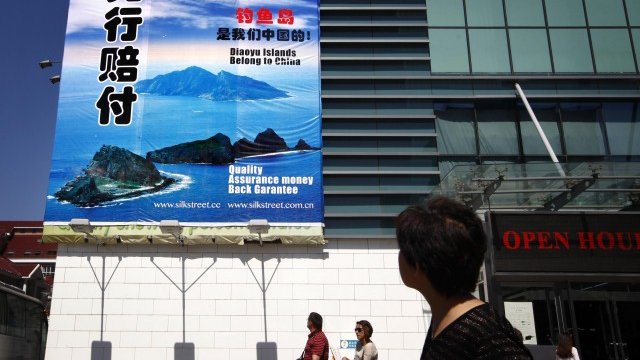 <p>
	&quot;Този магазин отказва да продава японски стоки&quot;, пише на рекламата на фона на спорните острови. <em>Снимка: Ройтерс</em></p>
