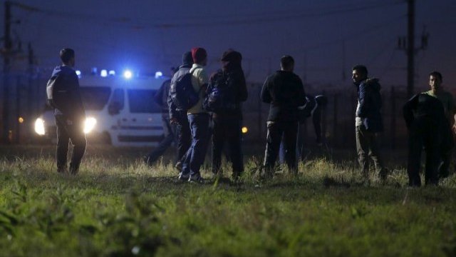 <p>
	Френската полиция задържа група мигранти в района на входа на тунела под Ламанша.<em> Снимка: Ройтерс</em></p>
