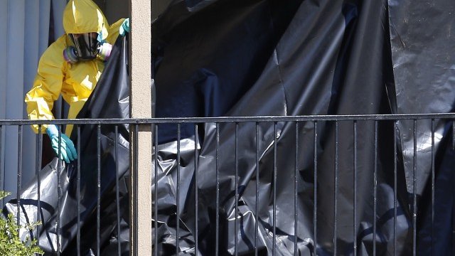 <p>
	Служител на здравните власти пред апартамента на Дънкън. <em>Снимка: Ройтерс</em></p>
