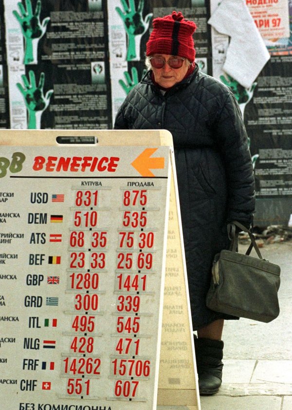 
	Пенсионерка гледа валутните курсове пред обменно бюро в София, 23 януари 1997 г. Тогава левът поевтинява до исторически ниските 875 лв. за един долар при 600 лв. за един долар в началото на януари 1997 г.&nbsp;Снимка: архив Ройтерс
