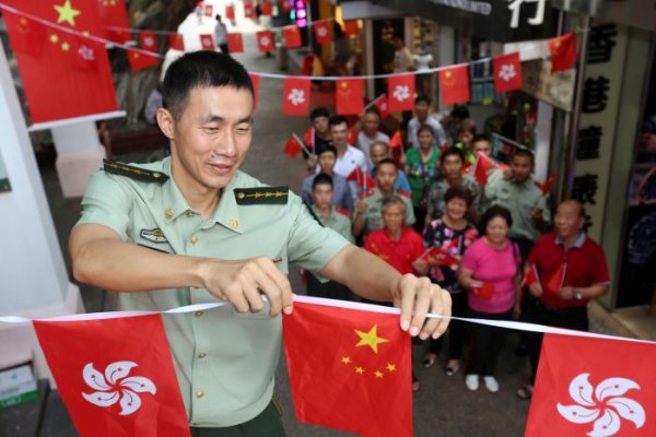 
	Полицай украсява със знамена на Китай и Хонконг по повод встъпването в длъжност на Кари Лам.

	Снимка: Ройтерс
