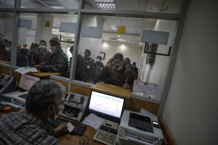 Палестинци чакат на опашка за получаването на 100 долара помощ от Катар в пощенски клон в Газа, февруари 2021 г. Снимка: Ali Jadallah/Anadolu Agency via Getty Images