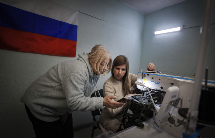 Жени шият камуфлажни мрежи за мъже, мобилизирани да участват в обявената от руския президент "специална военна операция" в Украйна, в доброволчески център в Лобня. Снимка: EPA/YURI KOCHETKOV