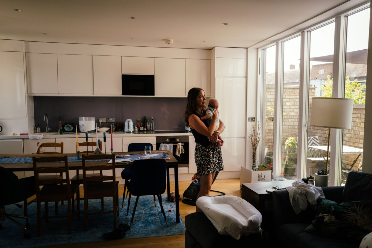 Емили Уилки и Дилън във всекидневната ѝ през август. В горещи дни в апартамента им е с три-четири градуса по-топло, отколкото навън. Снимка: Жозе Сарменту Матуш/Bloomberg