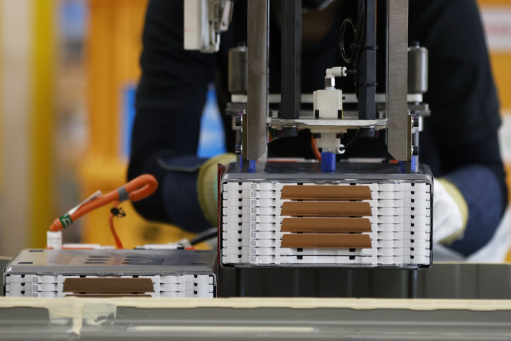 Работник монтира купчина литиево-йонни батерии върху акумулаторен пакет за електрически автомобил на производствената линия в Mitsubishi Motors Corp. Mizushima в Курашики, префектура Окаяма, Япония, в четвъртък, 19 май 2022 г.  Снимка: Kiyoshi Ota/Bloomberg