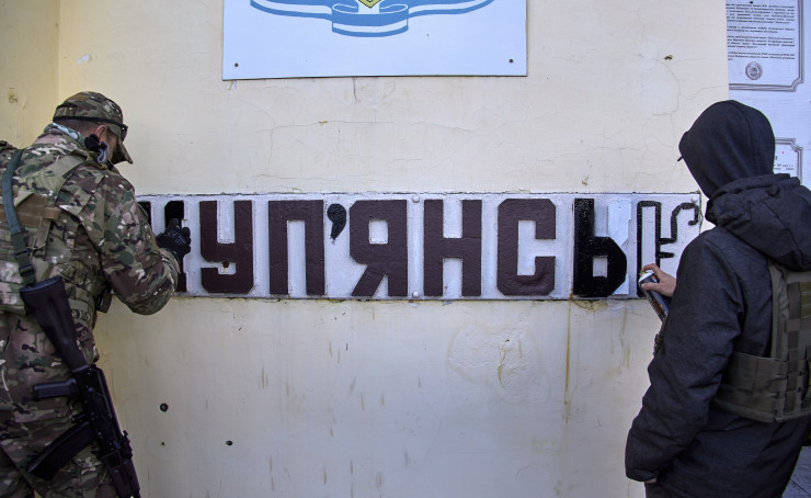 Украински военен и артист променят начина на изписване на град Купянск от руското му изписване на украинско. Снимка: ЕРА 