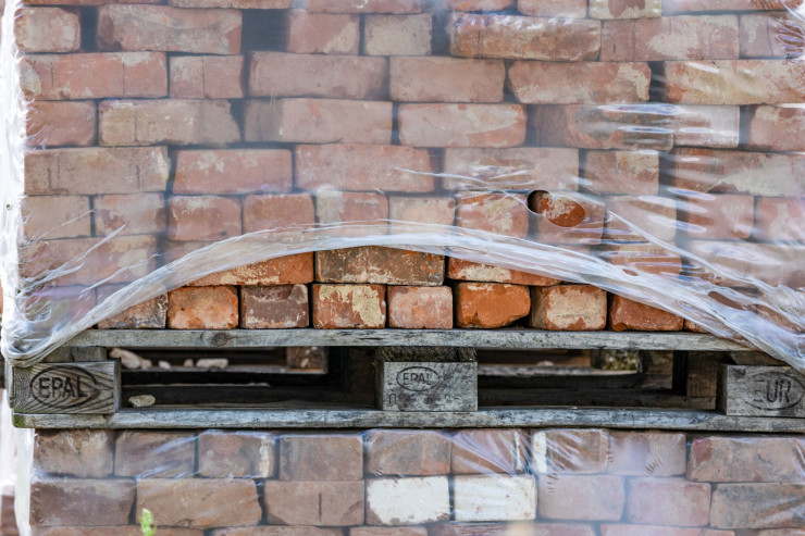 Палети с тухли на обект за жилищно строителство в Хамбург. Жилищното строителство се срива с повишаването на цените. Снимка: Мария Фек/Bloomberg