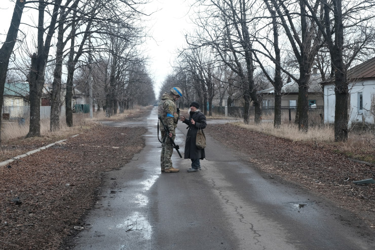 Украински военен разговаря с цивилни по време на свой патрул. Снимка: EPA/MARIASENOVILLA