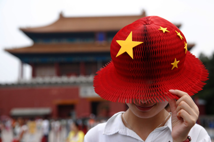 Жена носи шапка, имитираща дизайна на китайското национално знаме. Източник: Bloomberg L.P.