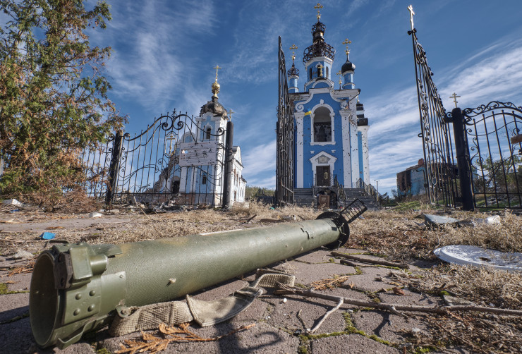 Оръжие пред полуразрушена църква в област Донецк. Снимка: EPA/BGNESS