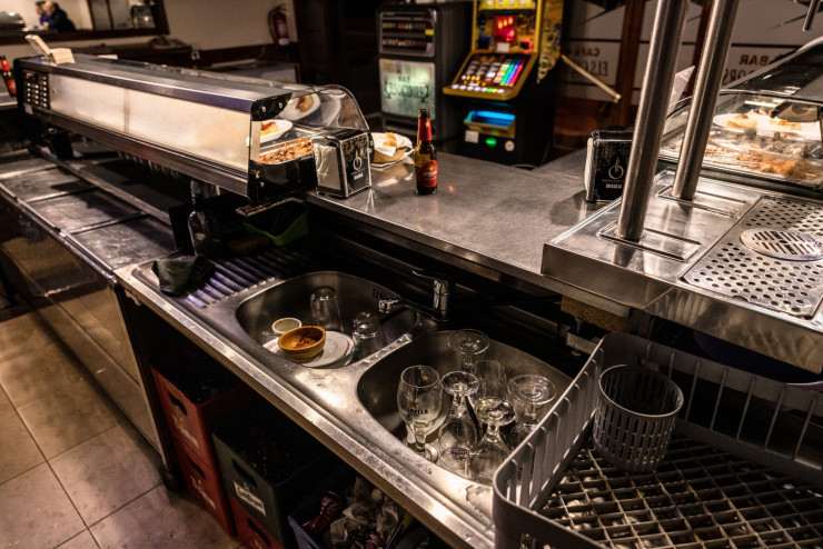 Съдове в мивката преди измиването им с бутилирана вода в Бар Елс Какадорс, където спирането на водата през нощта е следствие от сушата. Снимка: Анхел Гарсия, Bloomberg