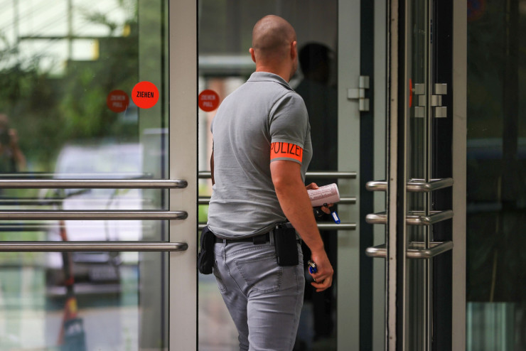 Полицай влиза в сграда на Adler в Берлин. Снимка: Bloomberg LP
