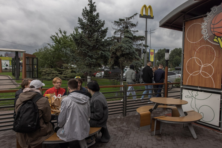 Граждани на Киев се хранят пред отворен отново обект на McDonald&#39;s. EPA/ROMAN PILIPEY