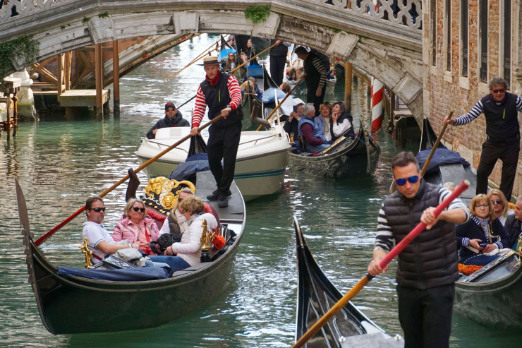 Гондолиери превозват туристи по канал във Венеция през април 2023 г.  Снимка: Андреа Мерола/Bloomberg