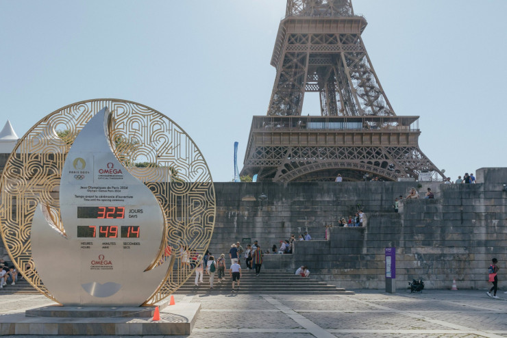 Посетители на мястото близо до Айфеловата кула, където се намира часовникът, отброяващ оставащото време до началото на Олимпиадата в Париж през септември 2023 г. Снимка: Андреа  Мантовани/Bloomberg